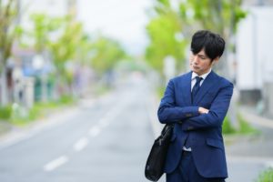 悩むスーツの男性