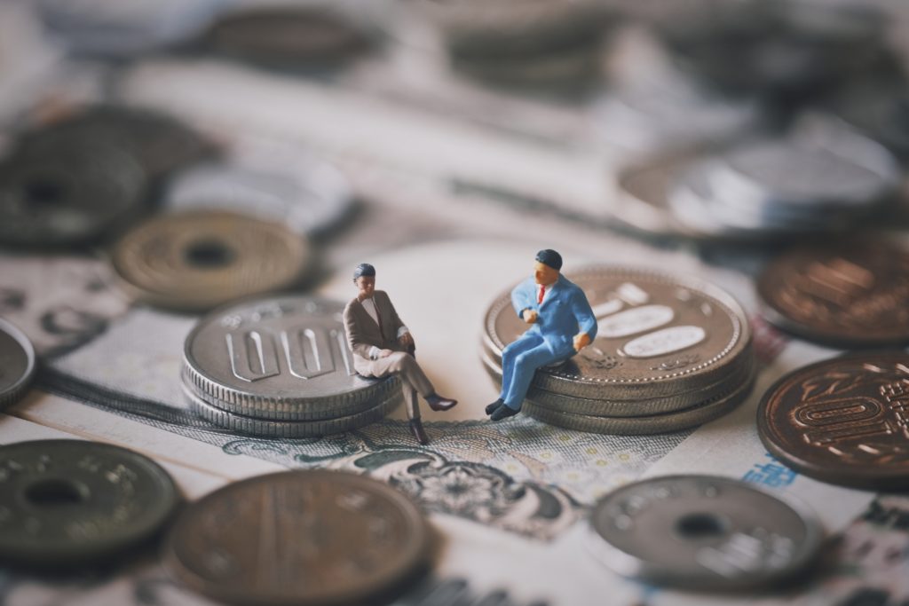 お金の上で話し合う男性二人